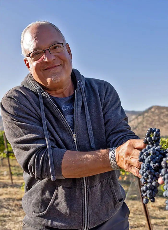 Alan Busacca holding a bunch of grapes