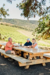 Alan, Steve, Nikki sitting at a picnic table at Windhorse.