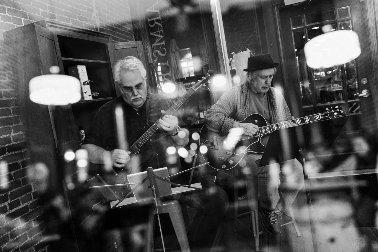 Black and white photo of two guys playing guitar