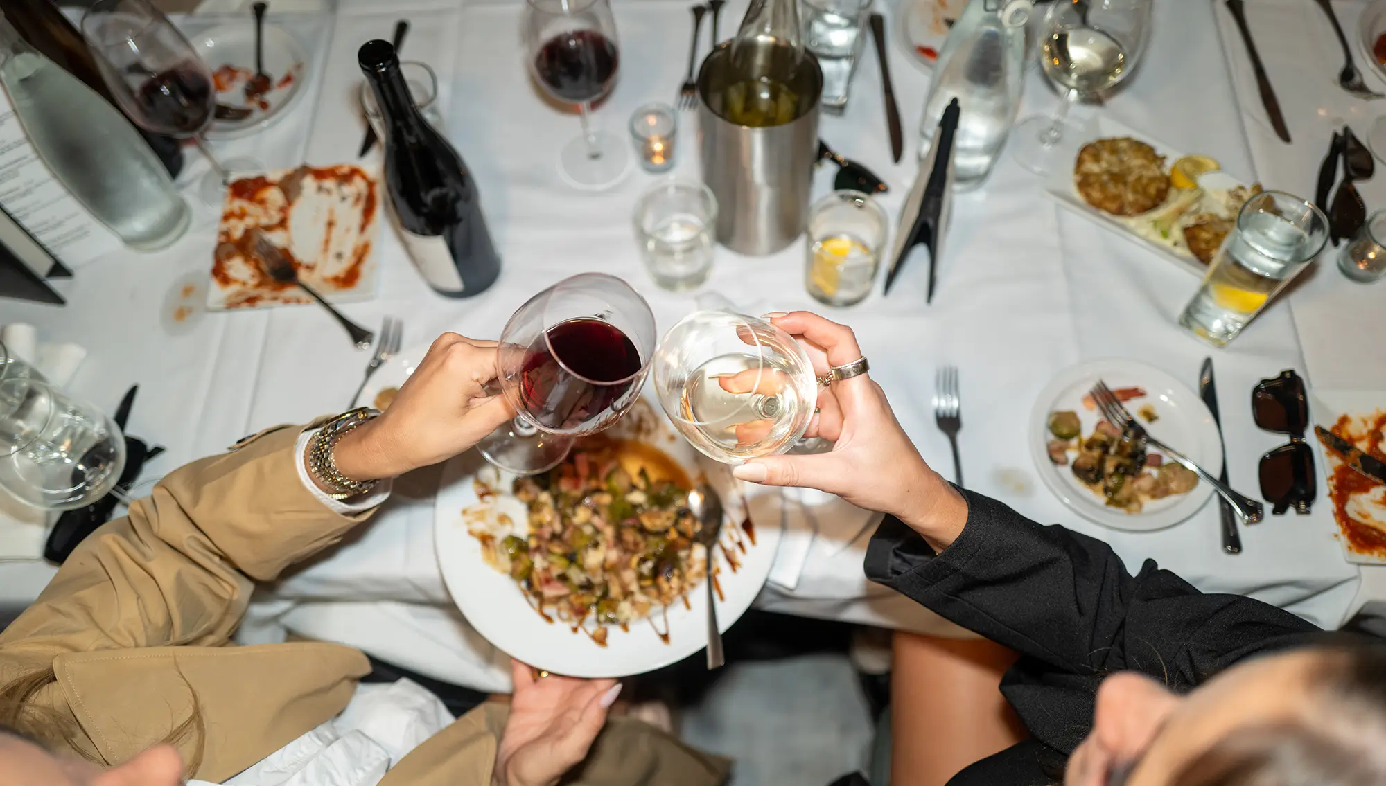 Two people cheers at dinner table