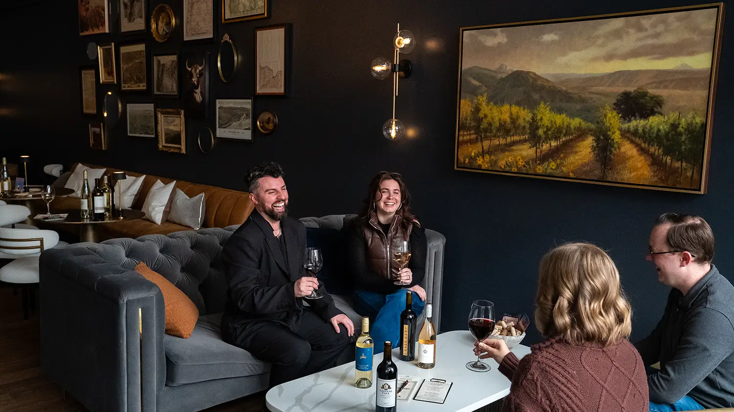A group relaxing on sofas drinking wine